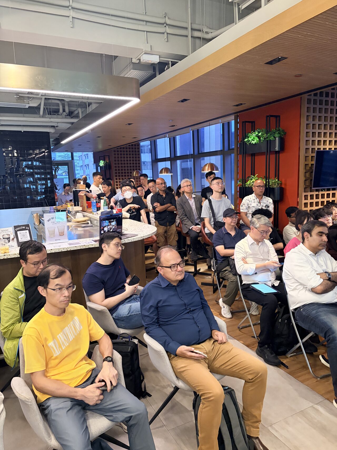 A packed crowd seated shoulder-to-shoulder watching the talks