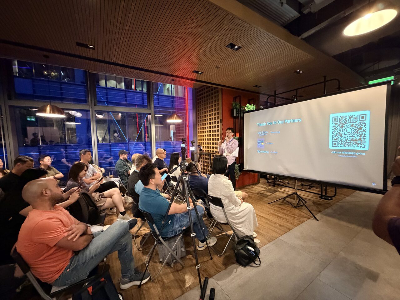 A wide shot of the full audience facing the big screen